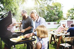 Family grilling together in a backyard