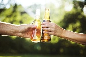 two hands holding beer