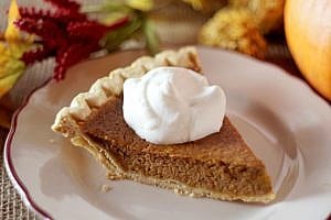 pumpkin pie with whip cream on a plate